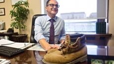 Alberta Finance Minister Joe Ceci Holds Up Dad's Old Workboots As Symbol Of Budget