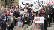 Topless Pro-Abortion Protester Disrupts News Conference In Quebec As Archbishop Reads Pope's Message