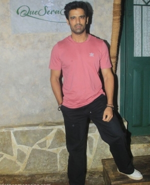 Mohit Malik casually poses in front of the press 