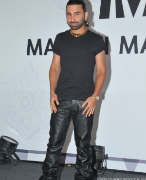 Orhan Awatramani is dressed in black and pairs it with gold accessories 