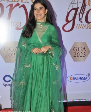 Isha Talwar smiles for the press in her emerald green suit 