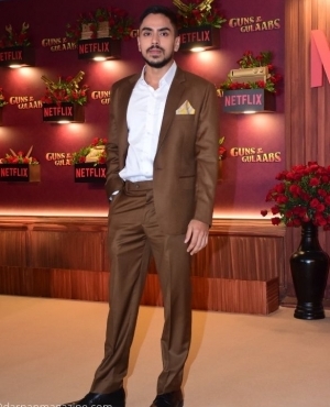 Adarsh Gaurav poses in his brown suit 