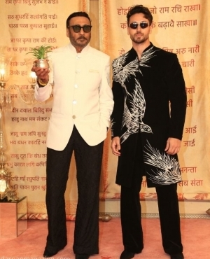Jackie Shroff holds a plant as he graces the occasion with his son Tiger Shroff