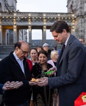 Premier David Eby lights the second set of diyas as MLA Chouhan holds the diyas 
