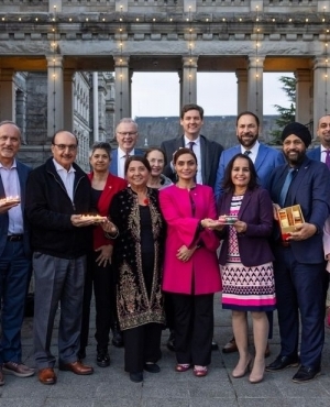Entire NDP caucus poses for a group photo holding well lit up diyas and mithai 