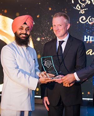 Amarjeet Singh on behalf of Naad Foundation receives the Hertiage Defender Award from Mark Taylor (center) and Bhupinder Singh (right) from Exclusive Floors