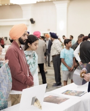 Raman showing records and old music labels to attendees 