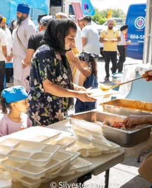 Staff serving hot meals to those at the Food Drive 