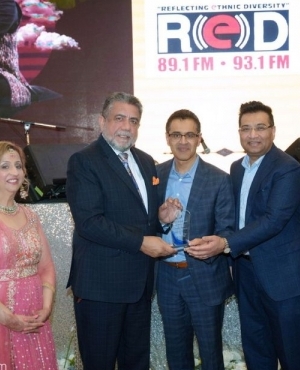 MP Sukh Dhaliwal presents a plaque to Kulwinder Sanghera and Bijoy Samuel of Red FM 93.1 