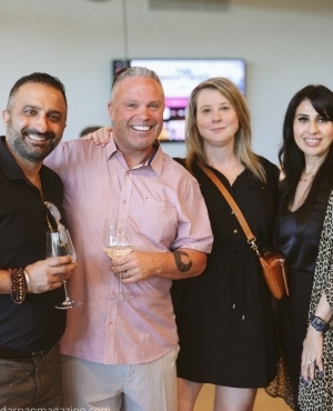 Men and women enjoying wine while posing for the camera 