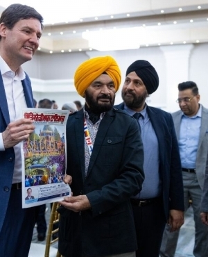 Premier David Eby holds a Punjabi newspaper 