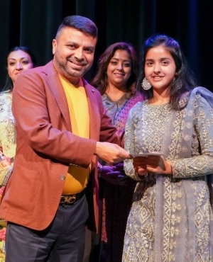 Rakesh Sharma of Alliance Immigration & Education Consulting Inc presents a token to Saanjh Jaura 