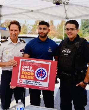 Delta Police Chief Neil Dubord along with another police officer are all smiles at the drive 