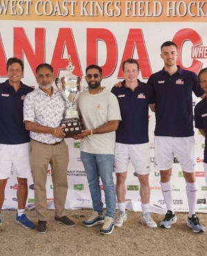 Balraj Mann and son Milan Mann pose with players holding the Canada Cup